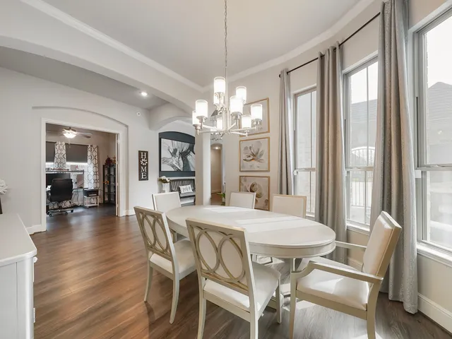 a view of a dining room with furniture large windows and wooden floor