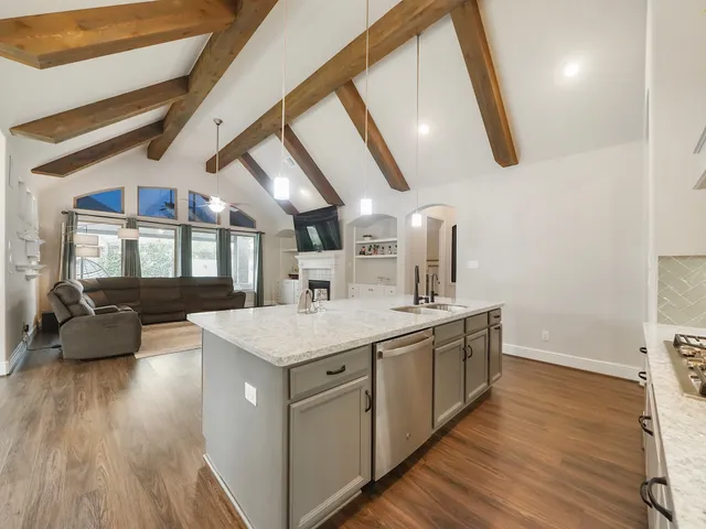 a kitchen with a sink and wooden floor