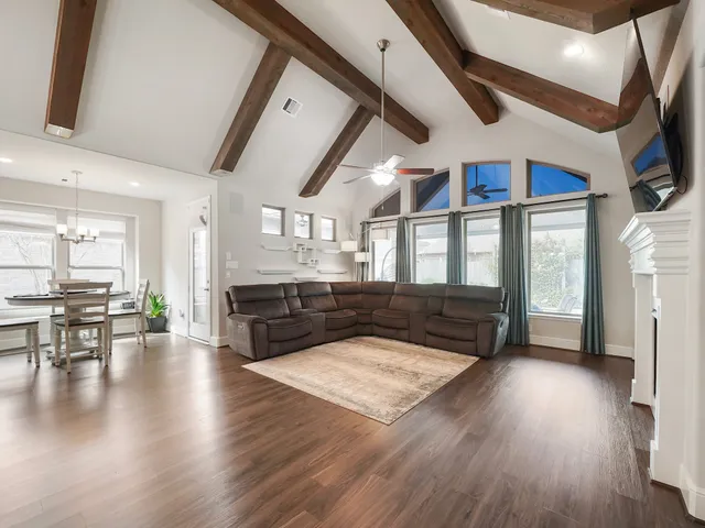 a living room with stainless steel appliances granite countertop a refrigerator a stove and a wooden floors