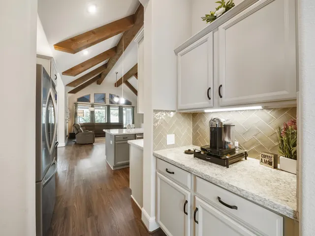 a kitchen with a refrigerator a stove and a wooden floors