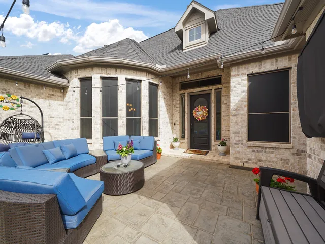a view of a patio with couches table and chairs and potted plants