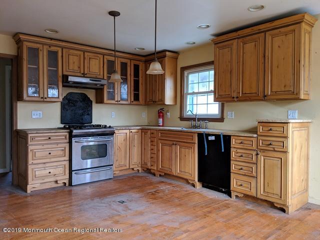 477 Pfister Road Jackson, NJ 08527 - Photo 3 of 21 a kitchen with kitchen island granite countertop a stove top oven a sink dishwasher and white cabinets with wooden floor