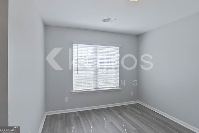 102 Colonial Way Springfield, GA 31329 - Photo 11 of 28 an empty room with wooden floor and windows