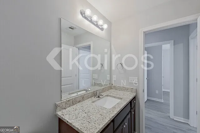 a bathroom with a granite countertop sink a mirror and a vanity