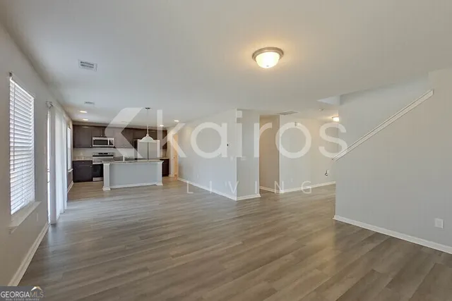 a view of a kitchen with a sink and dishwasher a refrigerator with wooden floor
