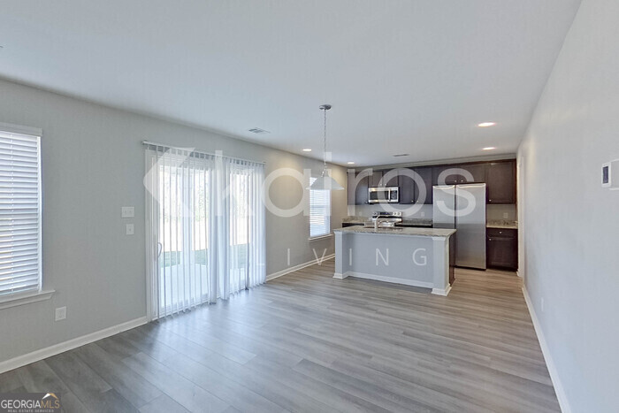 102 Colonial Way Springfield, GA 31329 - Photo 5 of 28 a kitchen with stainless steel appliances granite countertop a refrigerator a sink dishwasher a stove and white countertops with wooden floor