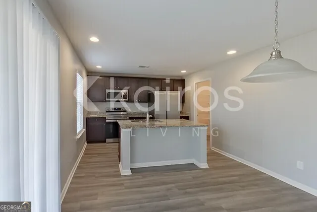 a kitchen with kitchen island stainless steel appliances a sink and stove