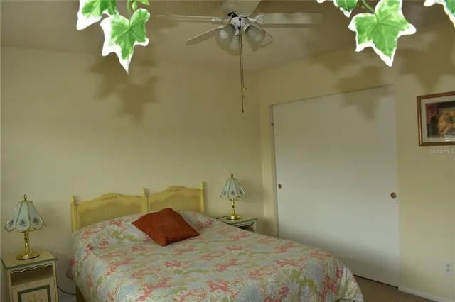 a bedroom with a bed mirror and lamp