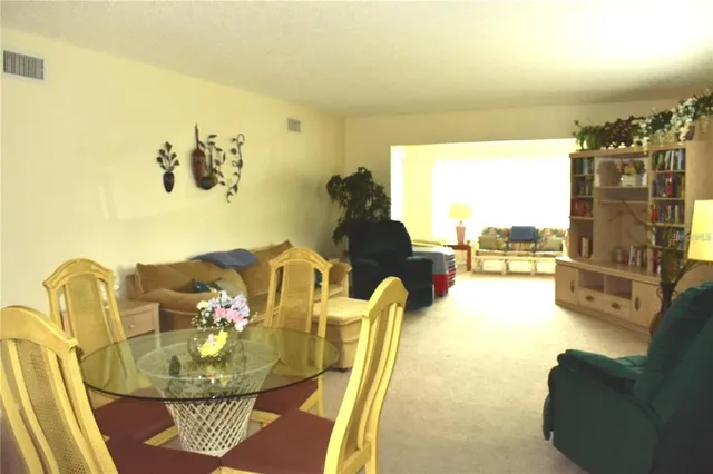a view of a dining room with furniture and a floor to ceiling window