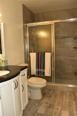 a bathroom with a granite countertop sink toilet and shower