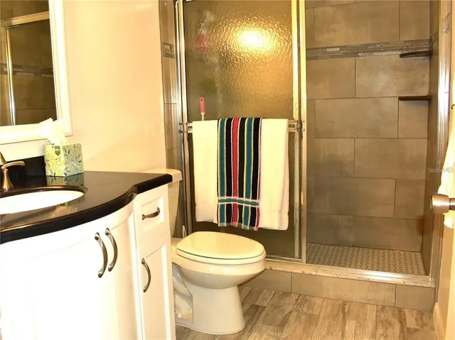 a bathroom with a granite countertop sink toilet and shower