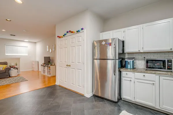 a kitchen with white cabinets and refrigerator