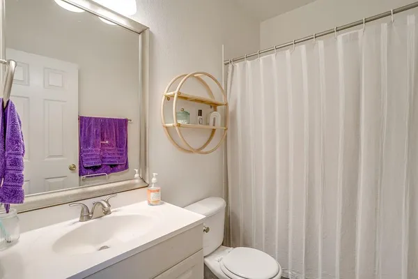 a bathroom with a sink vanity mirror and toilet
