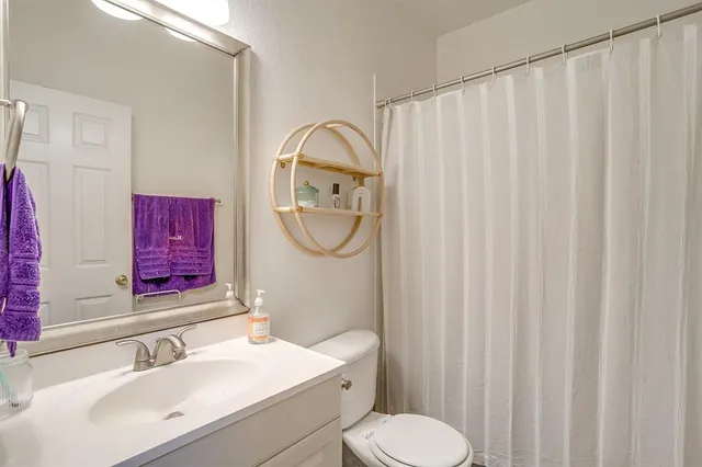 a bathroom with a sink vanity mirror and toilet