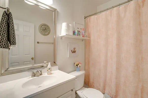 a bathroom with a sink a toilet and a mirror