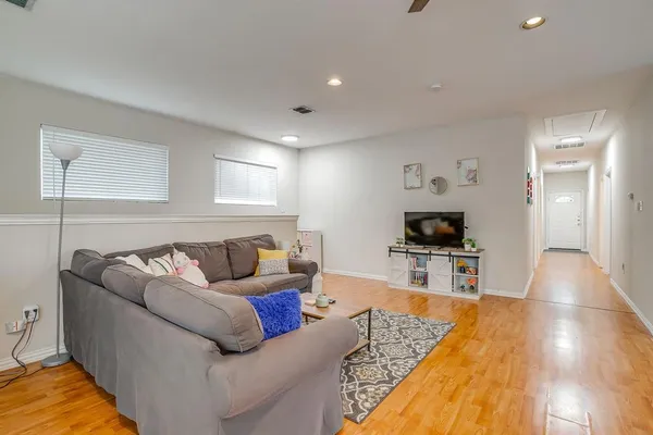 a living room with furniture and a wooden floor