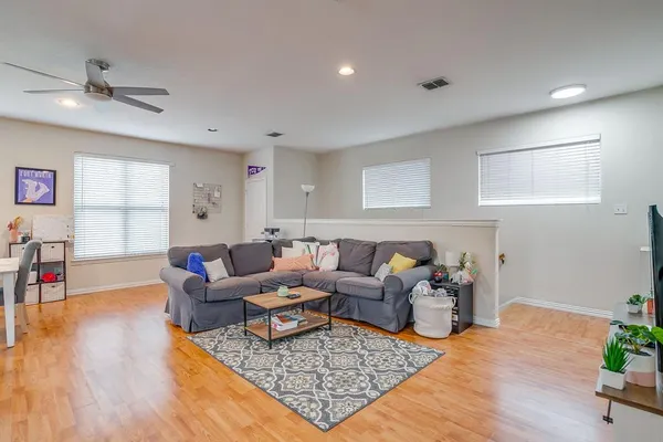 a living room with furniture and a wooden floor