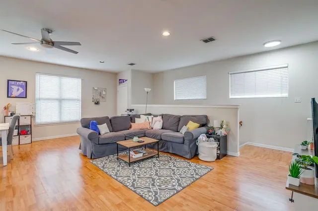 a living room with furniture and a wooden floor