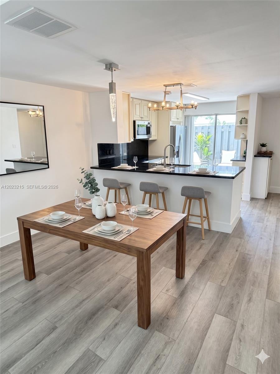 13 Southwest 3rd Street, Unit 13 Pompano Beach, FL 33060 - Photo 8 of 44 a room with a table chairs and wooden floor