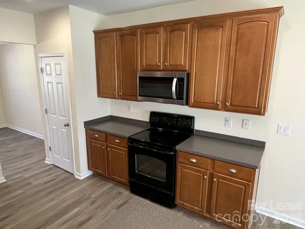 a kitchen with granite countertop wooden cabinets and a stove top oven