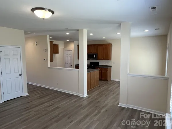 a view of a kitchen with wooden floor and a refrigerator