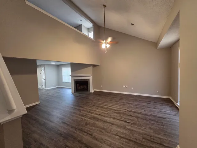 an empty room with wooden floor and fireplace