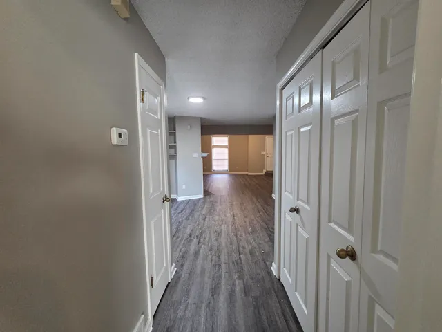 a view of a hallway with wooden floor and staircase
