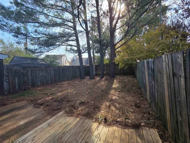 a view of a backyard with wooden fence