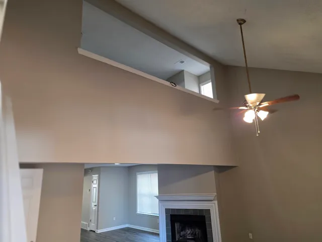 a view of a livingroom with a chandelier fan and a fireplace