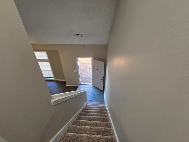 a view of a hallway with wooden floor and staircase