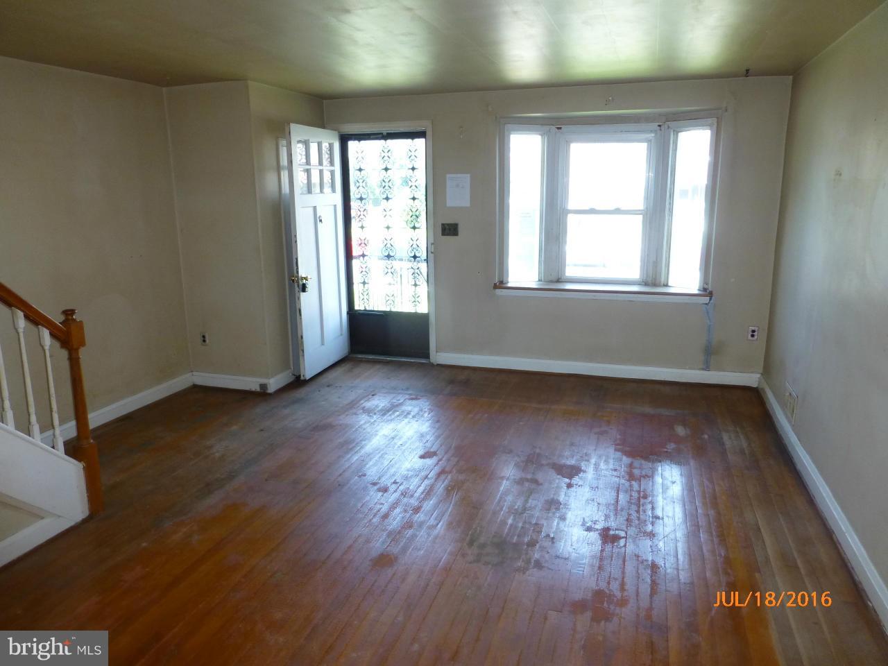 1933 Penhall Road Baltimore, MD 21222 - Photo 4 of 15 an empty room with wooden floor and windows
