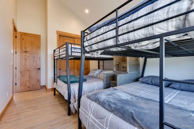 a bedroom with two beds and wooden floor