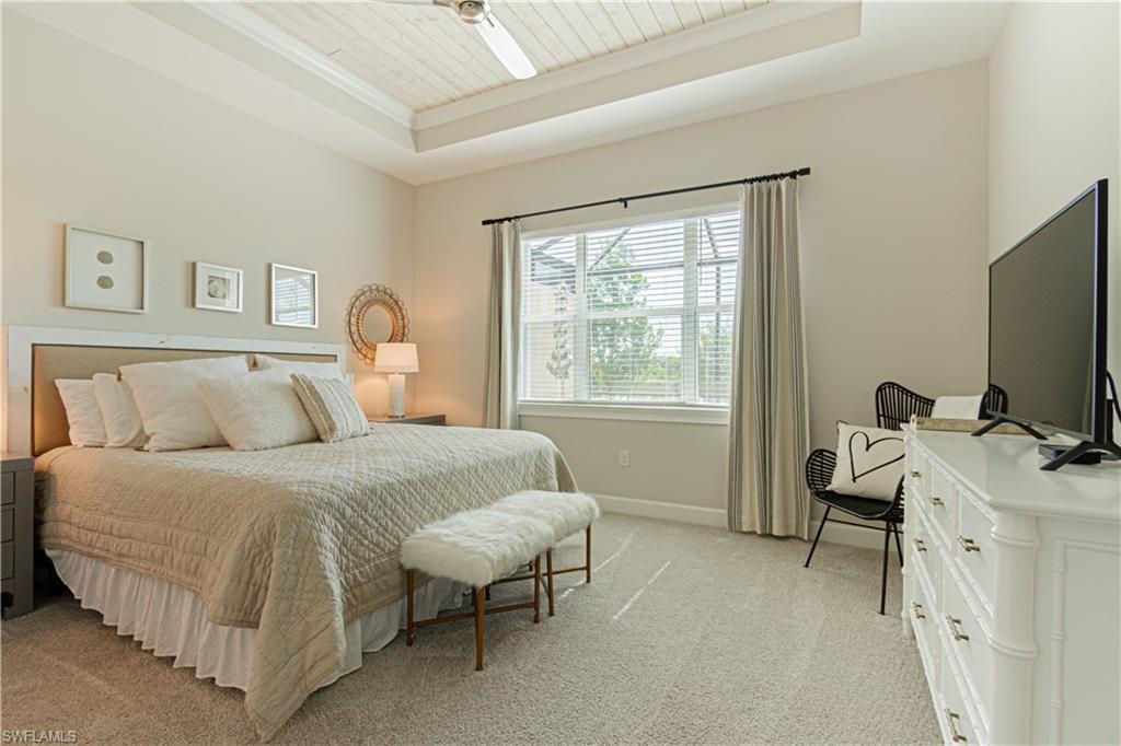 5834 Haiti Drive Naples, FL 34113 - Photo 13 of 33 a bedroom with a bed and a flat tv screen on the dresser