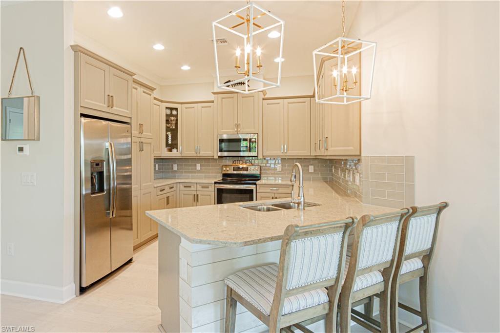 5834 Haiti Drive Naples, FL 34113 - Photo 6 of 33 a kitchen with kitchen island a counter top space appliances and cabinets