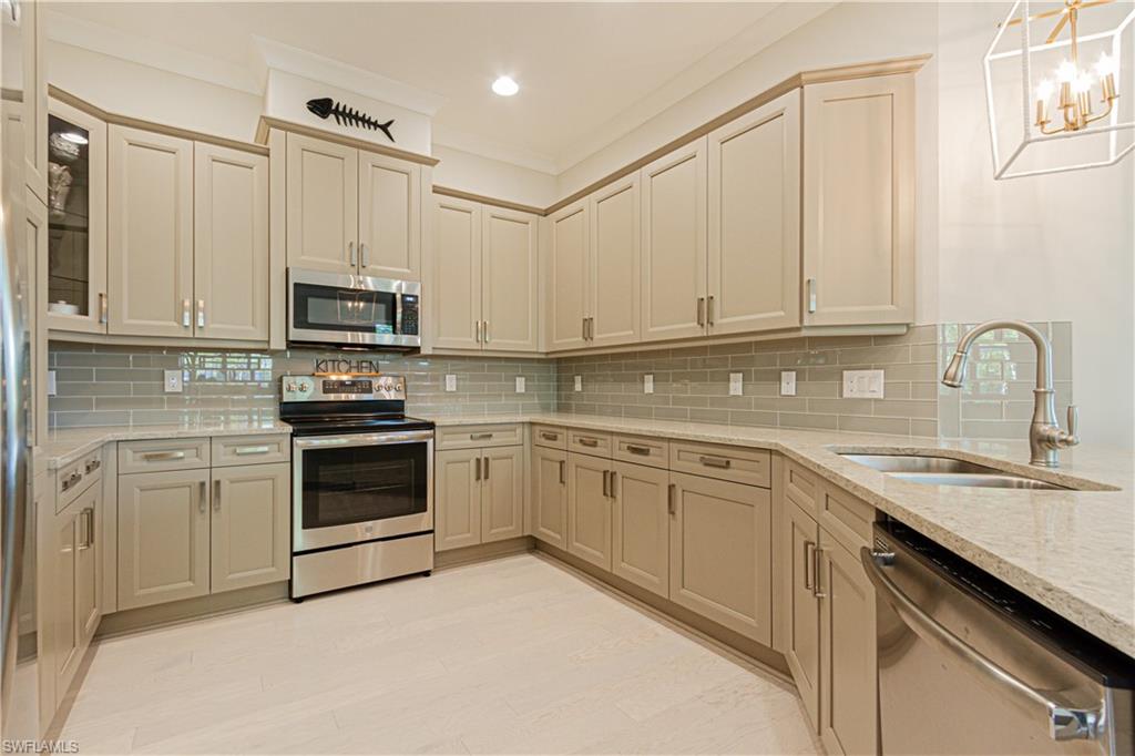 5834 Haiti Drive Naples, FL 34113 - Photo 7 of 33 a kitchen with cabinets appliances a sink and a counter top