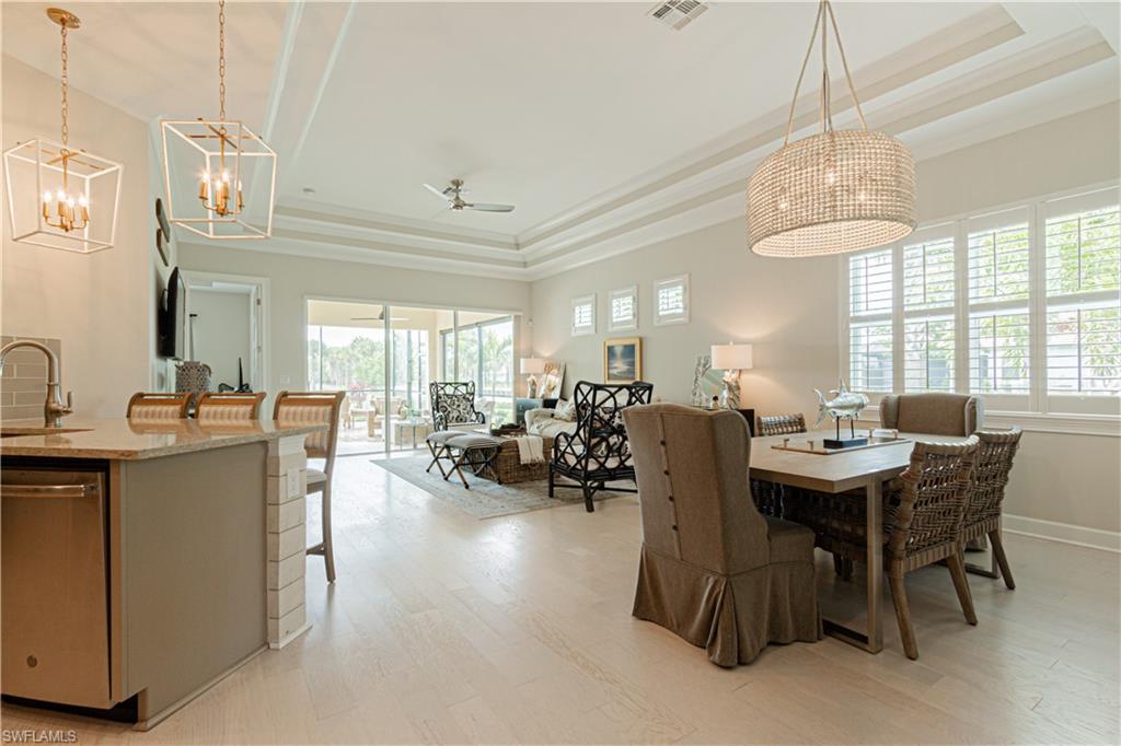 5834 Haiti Drive Naples, FL 34113 - Photo 9 of 33 a dining room with furniture a chandelier and wooden floor