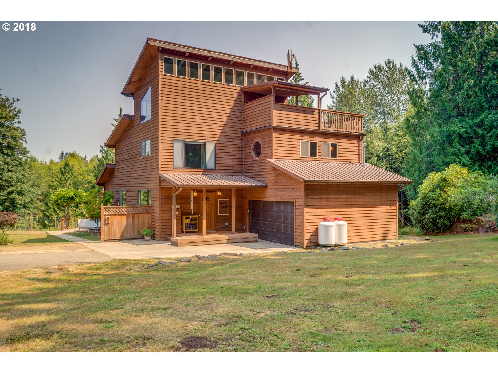 a view of a big house with a big yard and large trees