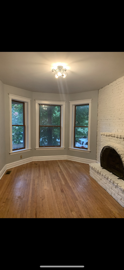 Undisclosed Address Chicago, IL 60613 - Photo 18 of 22 a view of an empty room with window and fireplace