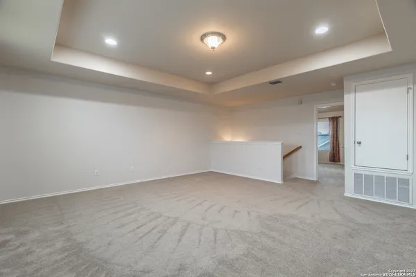 an empty room with white cabinet and windows