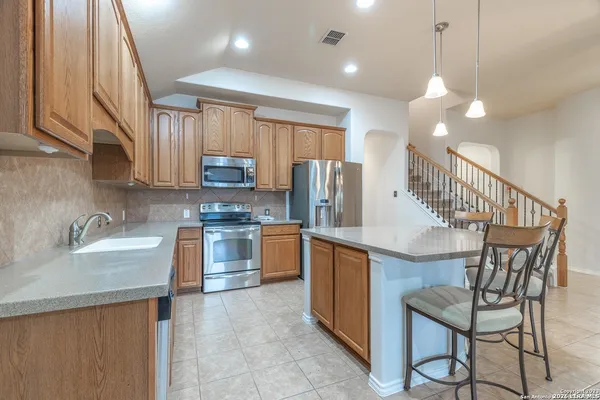 a kitchen with granite countertop a stove cabinets and refrigerator