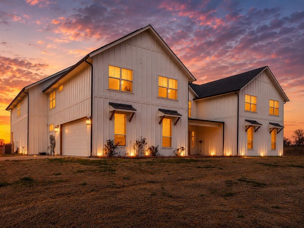 4600 Old Brock Road Weatherford, TX 76087 - Photo 2 of 37 Modern farmhouse exterior featuring vertical white siding, black-framed windows, dark roofing, decorative awnings, and integrated exterior lighting