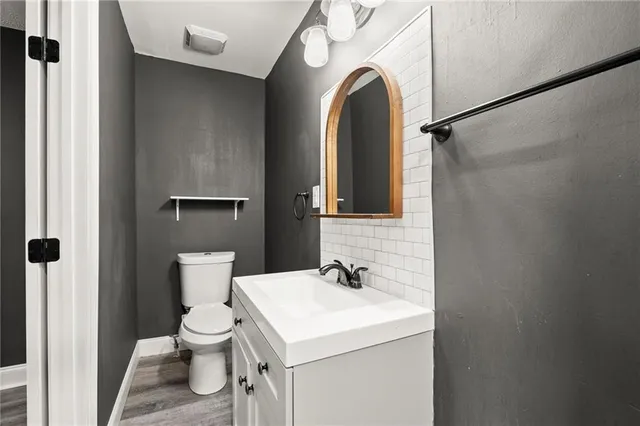 a bathroom with a sink mirror vanity and toilet