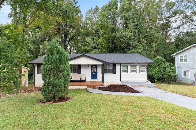 a front view of a house with a yard and trees