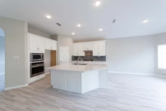 a view of kitchen with microwave oven stove and oven
