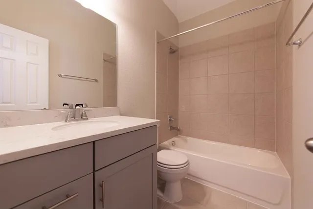 a bathroom with a granite countertop sink a toilet and shower