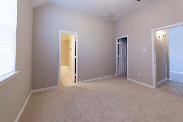 an empty room with windows and closet