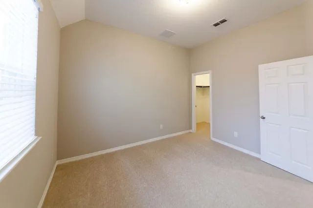 an empty room with closet and windows