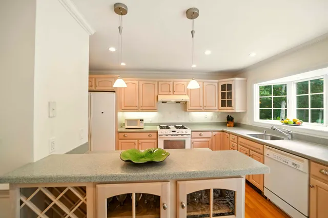 a kitchen with stainless steel appliances granite countertop a sink a stove and a refrigerator