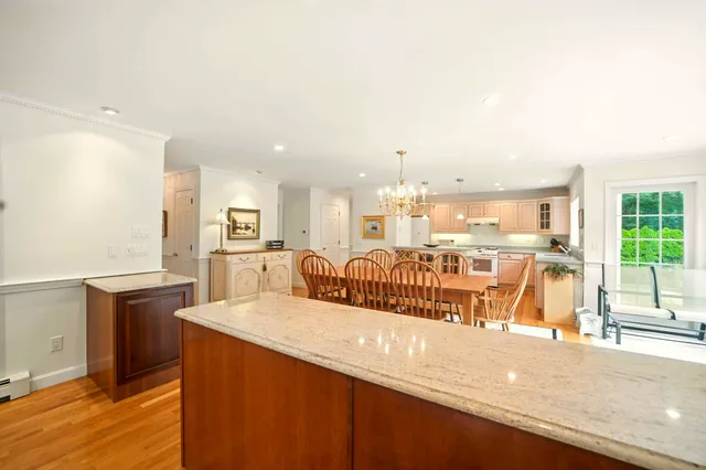 a view of a kitchen with kitchen island a large counter top space a sink stainless steel appliances and cabinets