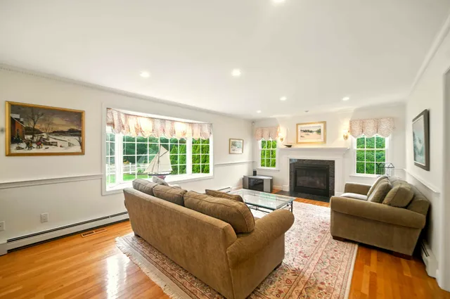 a living room with furniture a large window and a fireplace